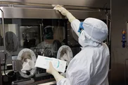 person in white hazmat suit cleaning a surface with wipes